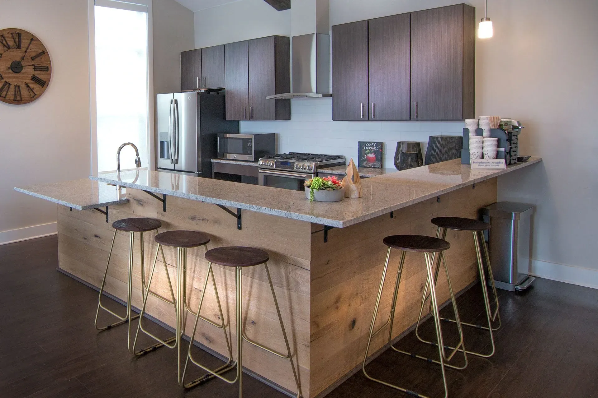 Modern kitchen with granite countertops, stainless steel appliances, and wood accents.