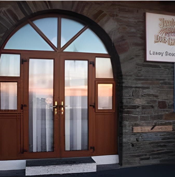 Brown arched doorway with glass panels. Sign Interior visible through glass. Stone wall to right.
