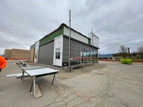 A man is standing in front of a building under construction.