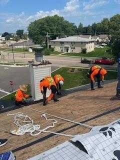 A group of construction workers are working on a roof.