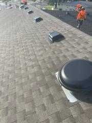 A man is working on the roof of a building.