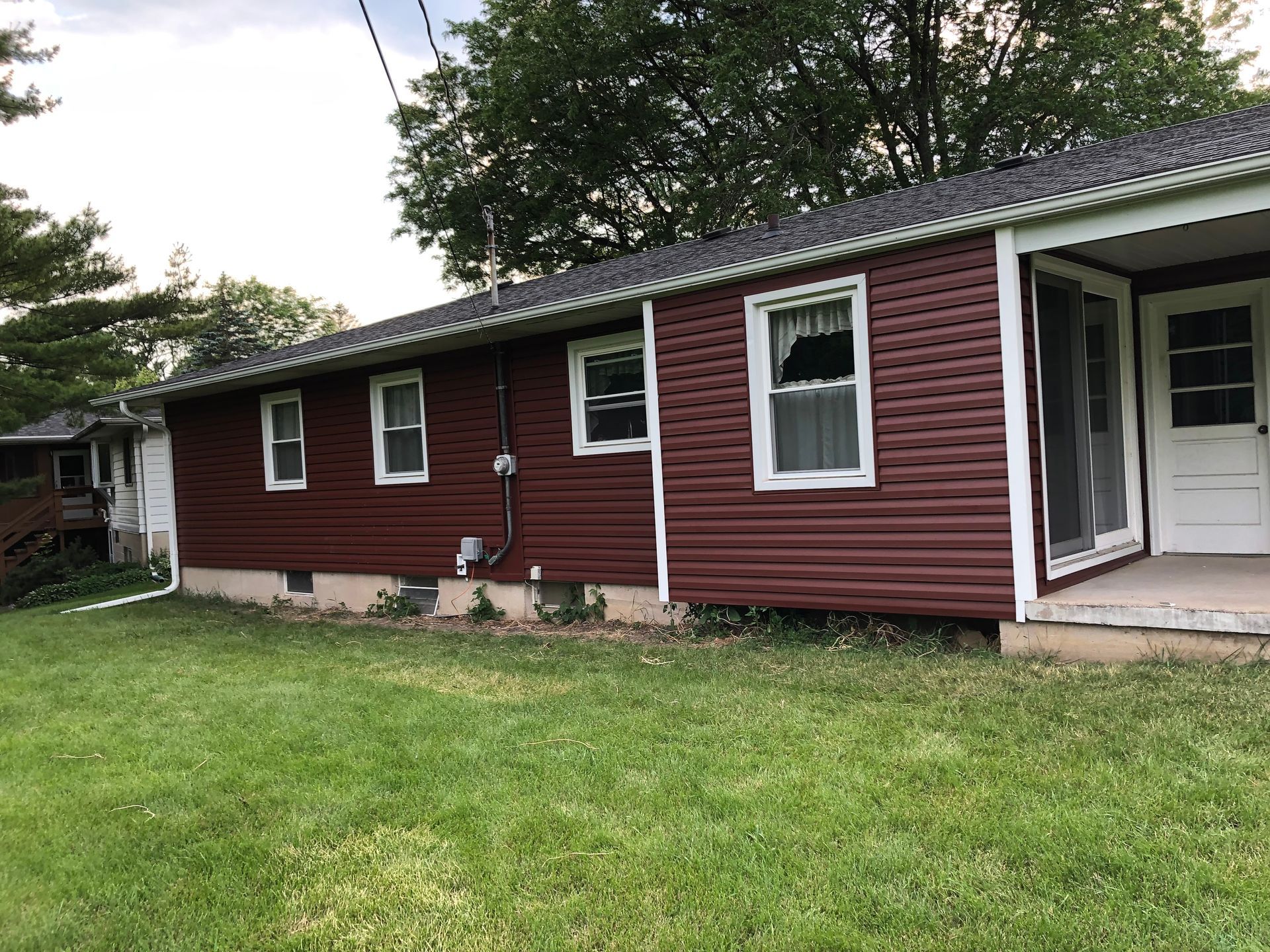 A delivery man is holding a black bag and standing in front of a door.