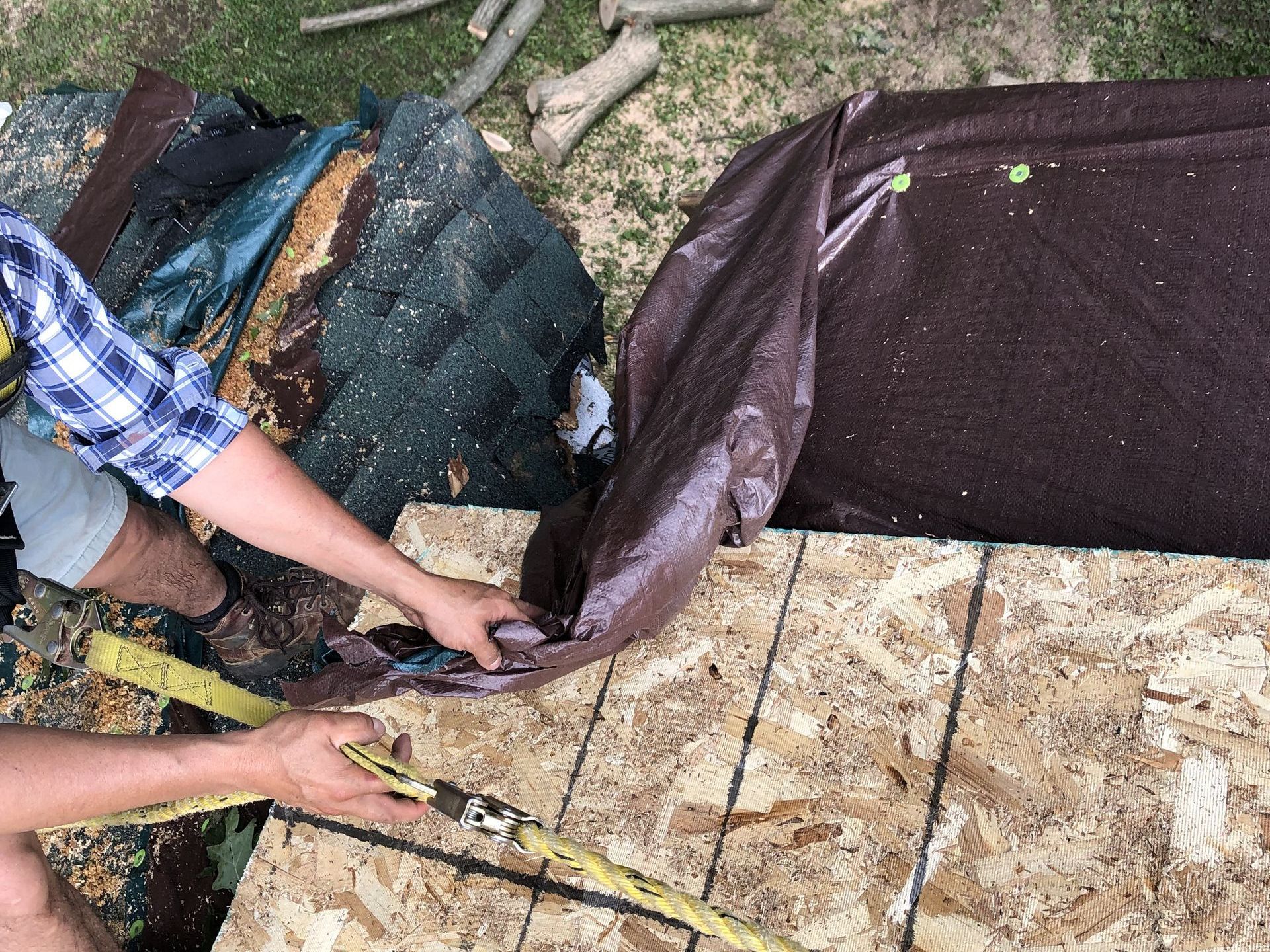 A man is measuring a piece of plywood with a tape measure.