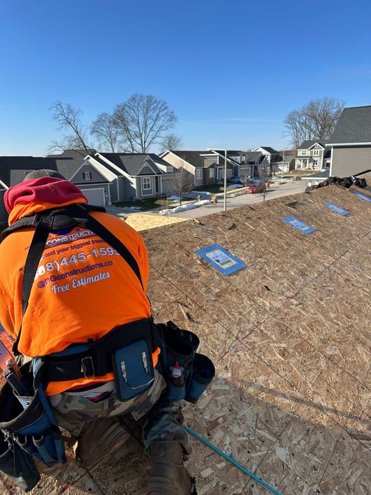 Two men are working on the roof of a building