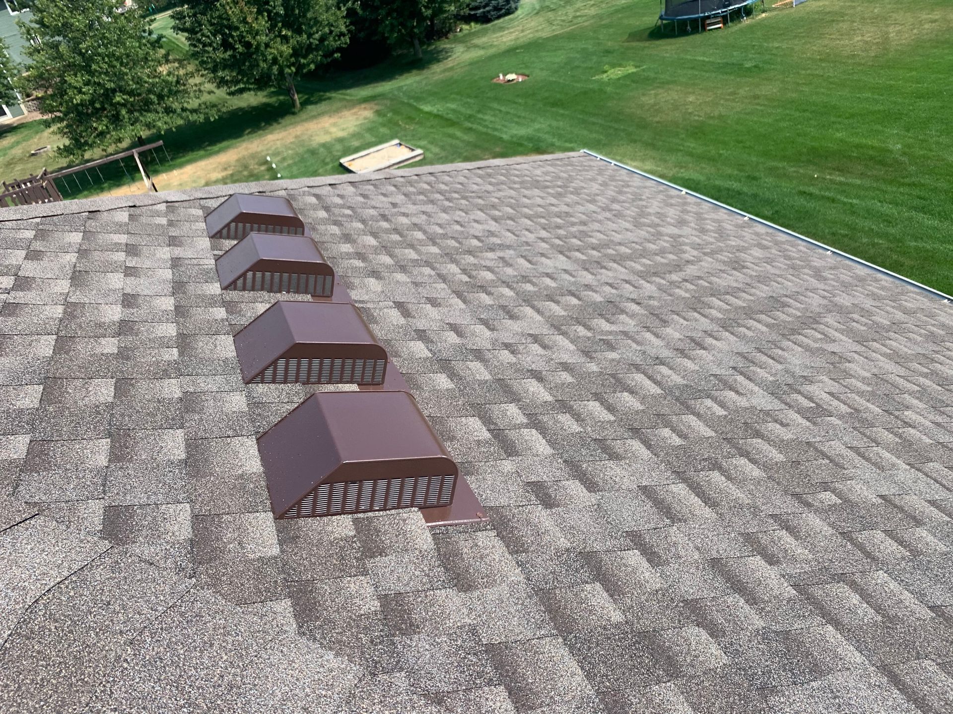 A man is kneeling on a window sill working on a window.