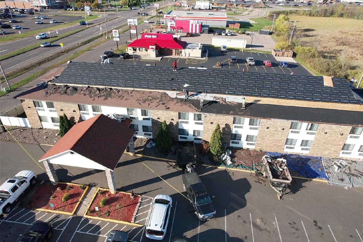 An aerial view of a hotel with cars parked in front of it