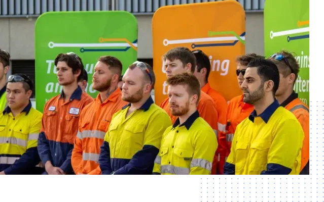 A group of men standing next to each other in front of a sign that says ' training ' on it.