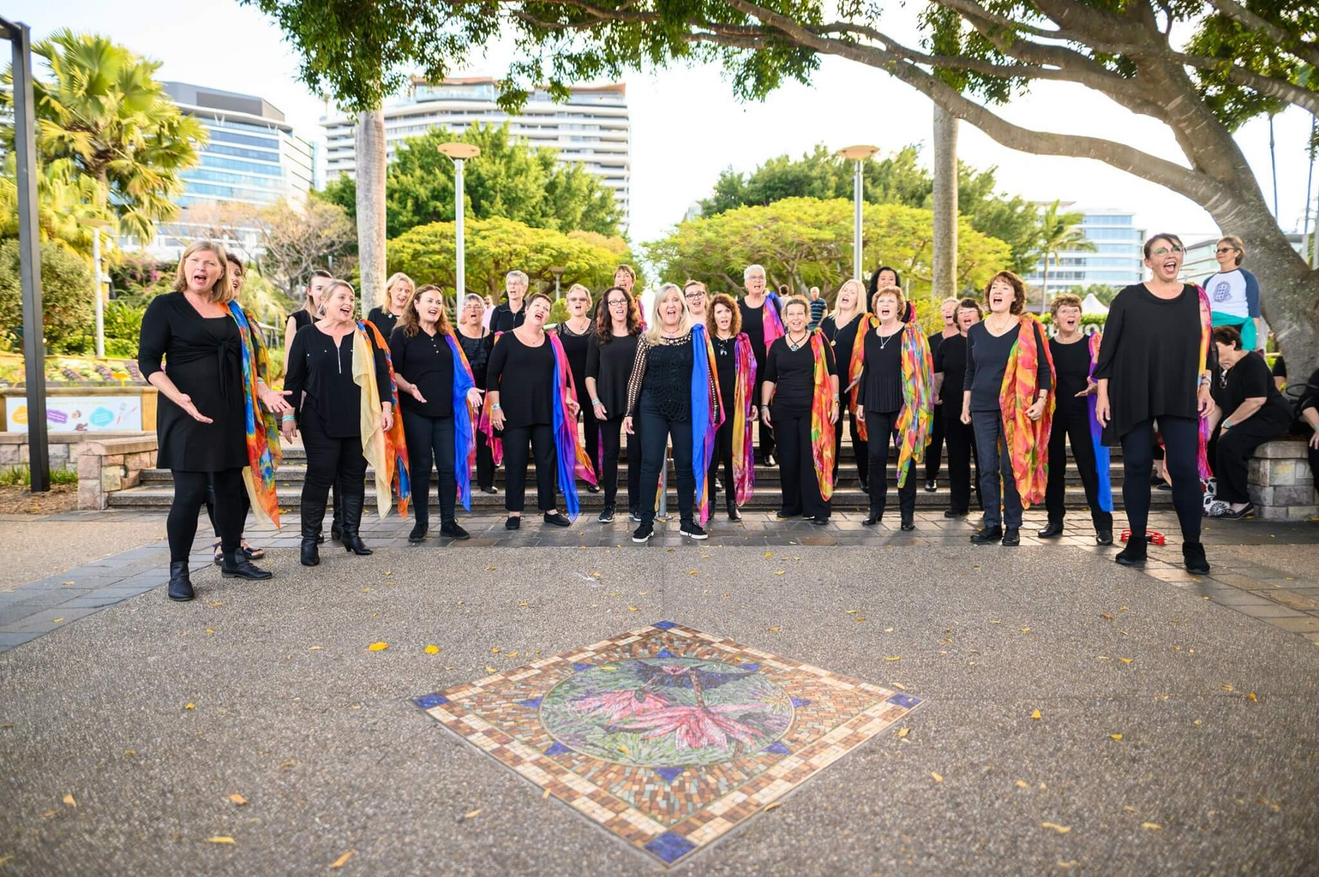 A large group of people are posing for a picture in a park.