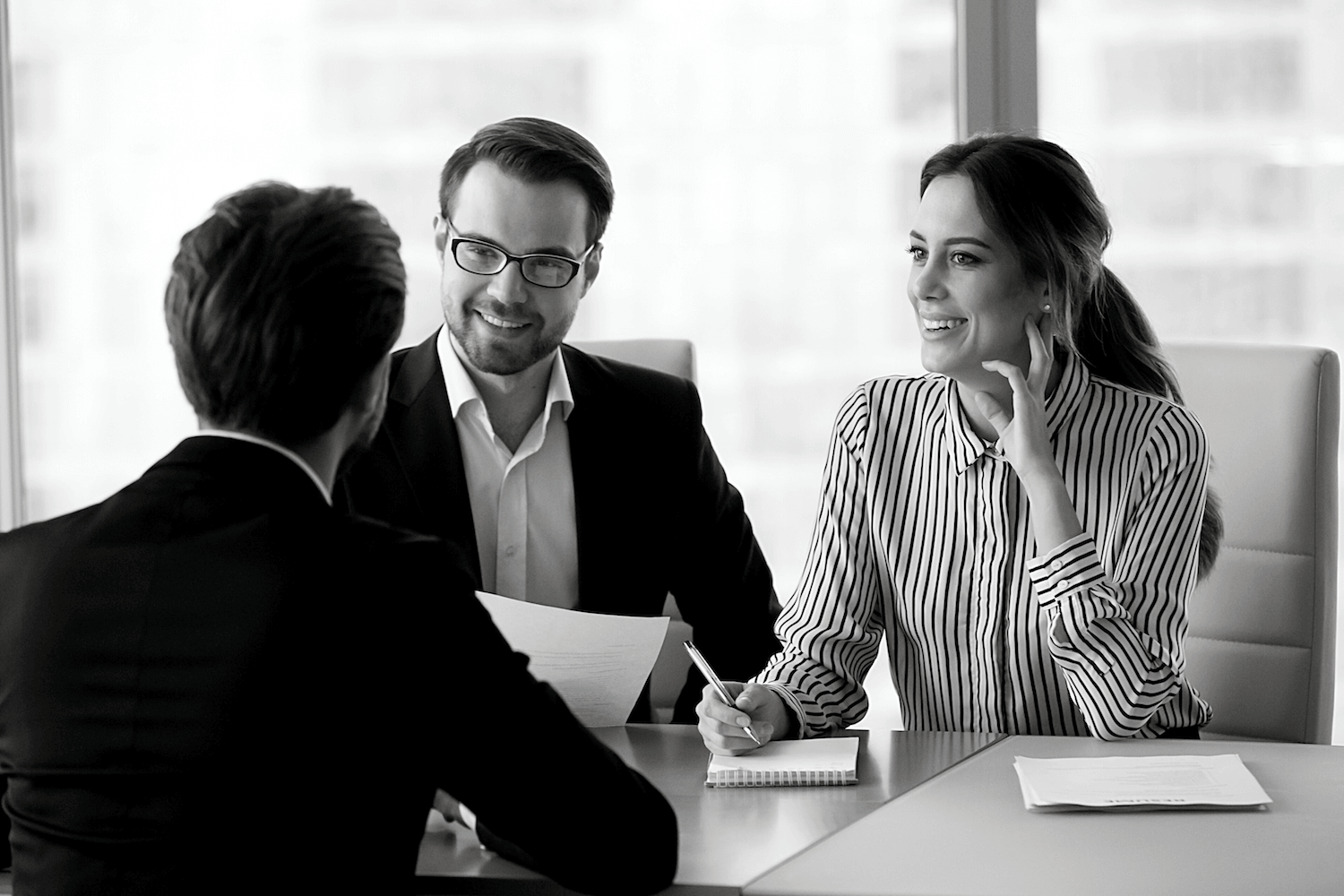 A group of people are sitting at a table having a meeting.