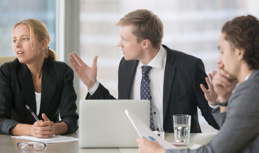 A group of business people are sitting at a table having a meeting.