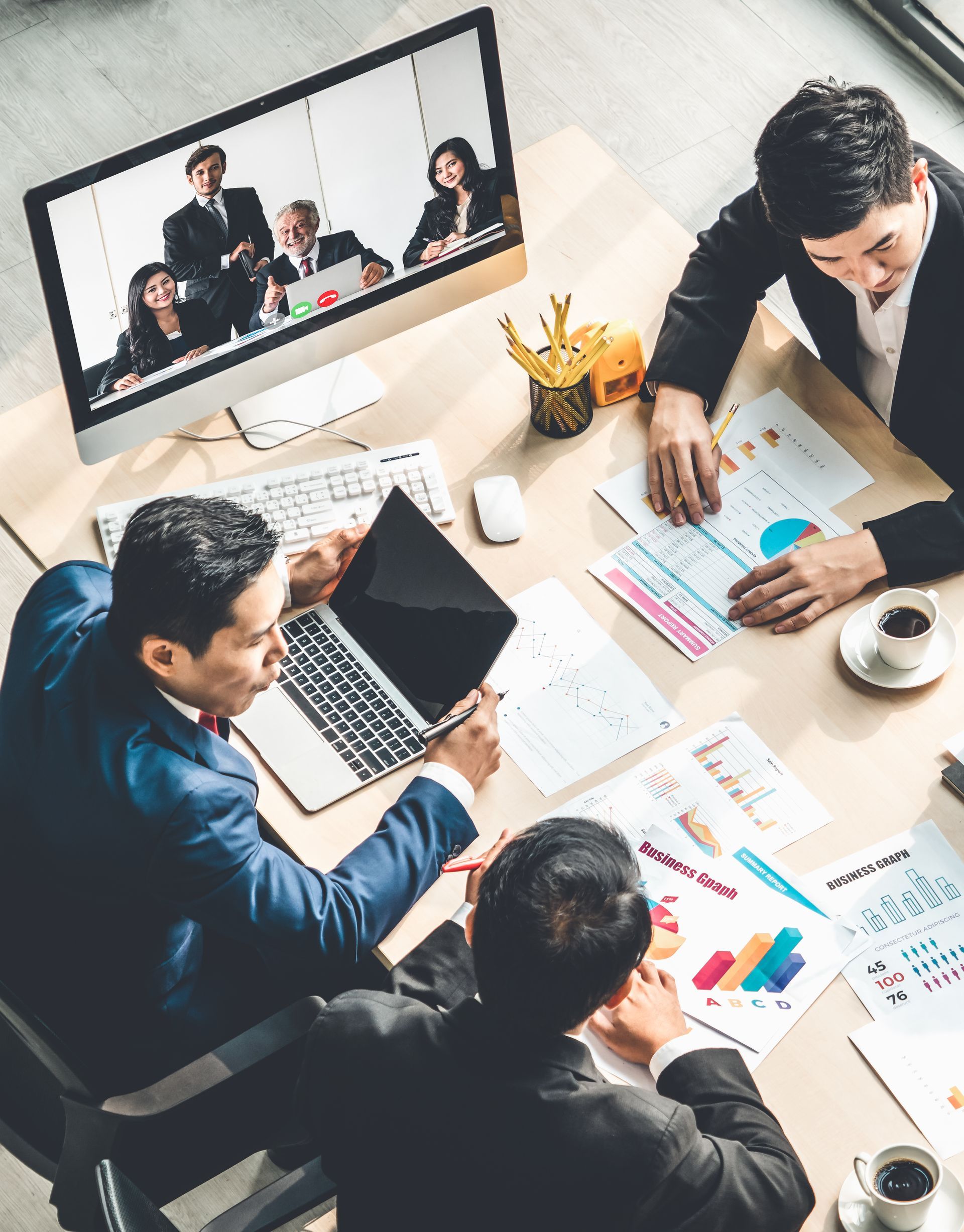 A group of business people are sitting around a table having a meeting.