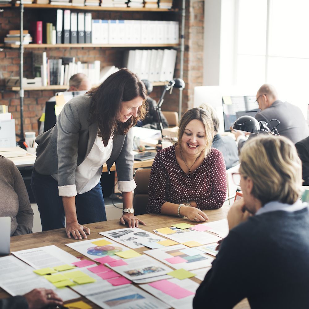 A group of people are sitting around a table with papers on it