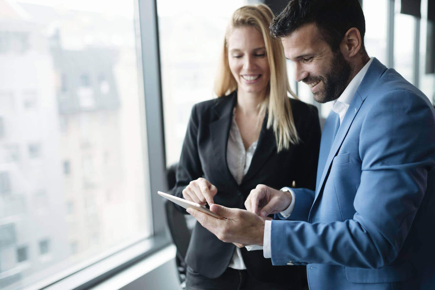 A man and a woman are looking at a tablet together.