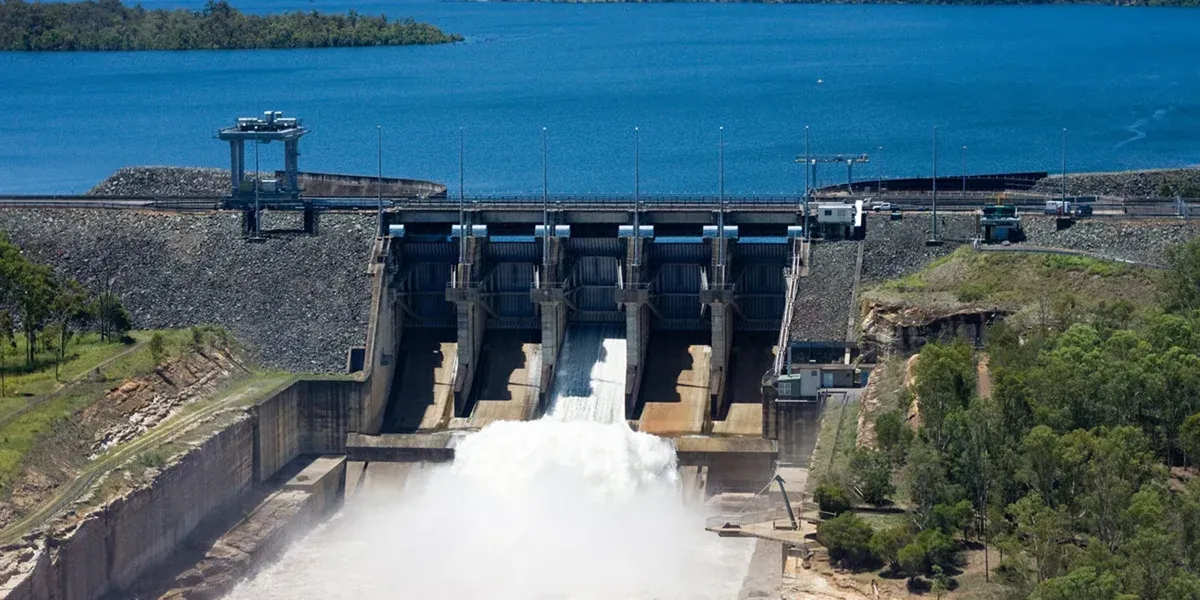 An aerial view of a dam with water coming out of it.