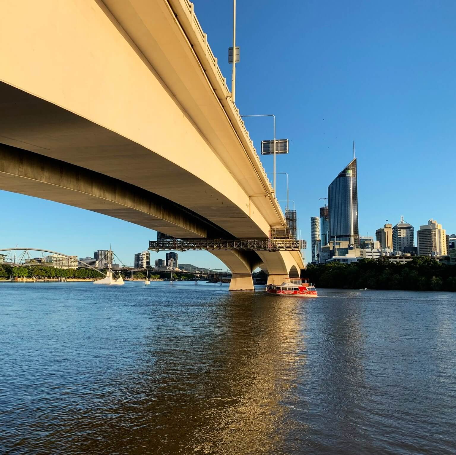 A bridge over a body of water with a city in the background