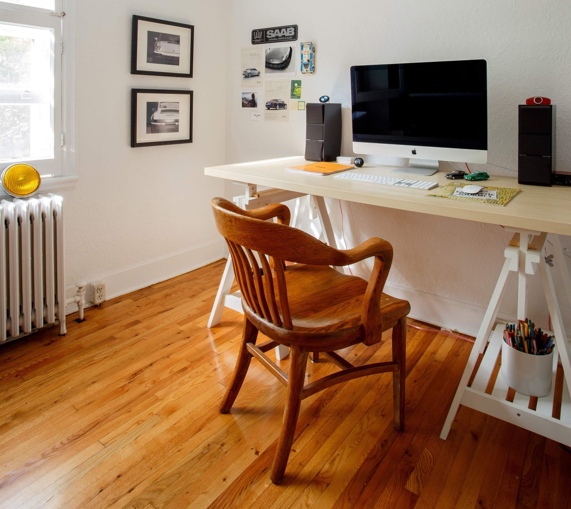 A wooden chair sits in front of a desk with a computer on it