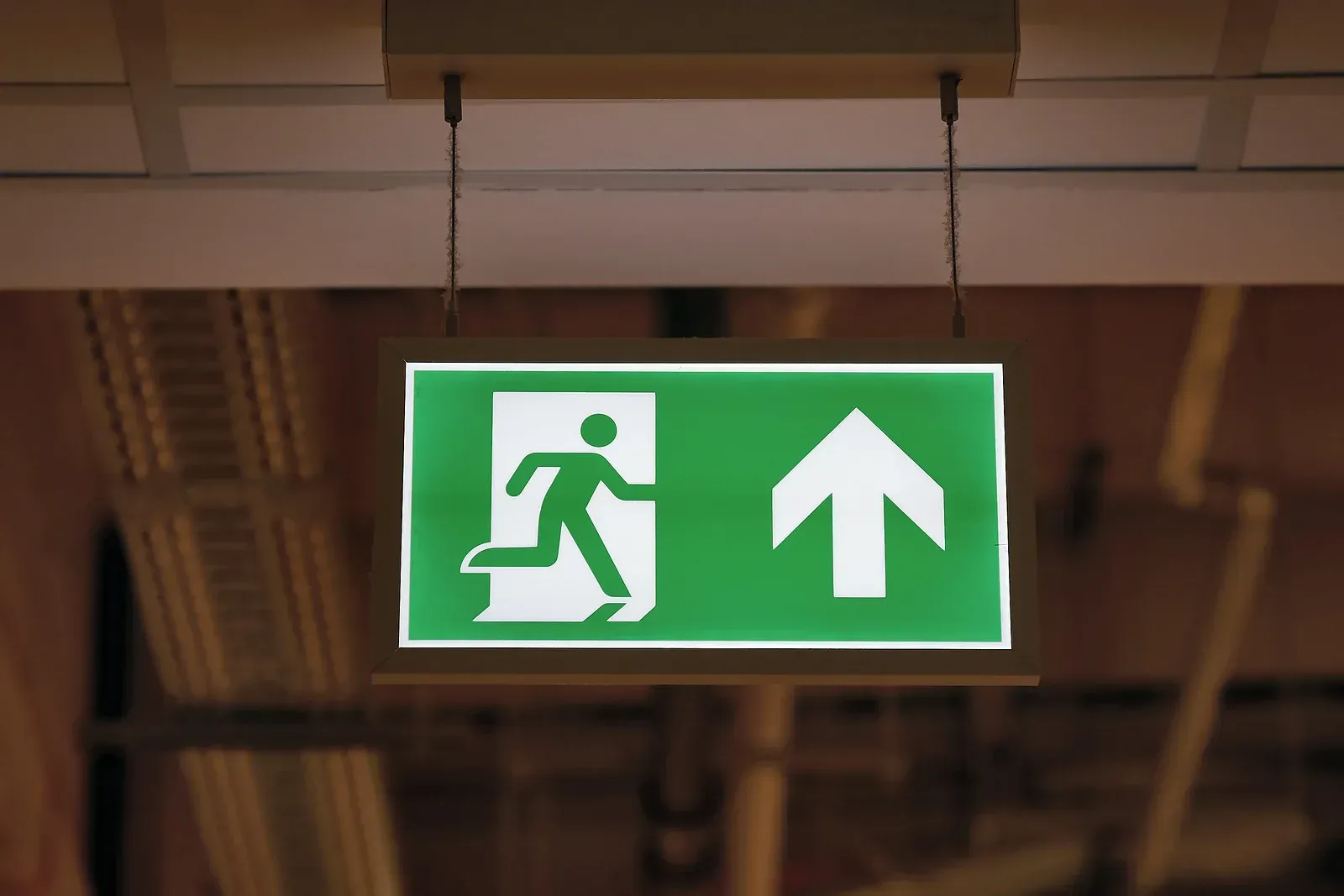 A green exit sign with an arrow pointing up