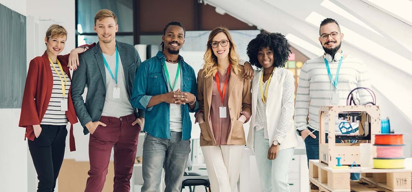 A group of people are standing next to each other in an office.