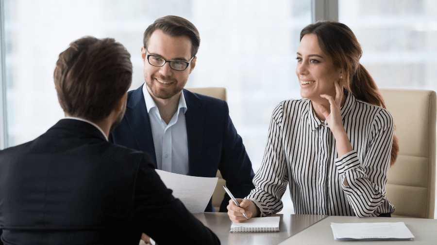 A man and a woman are sitting at a table having a job interview.