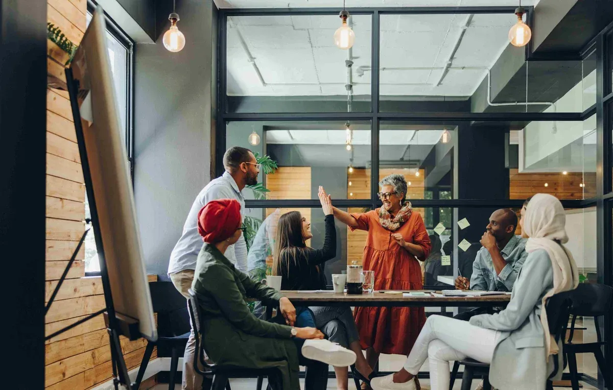 A group of people are sitting around a table in a conference room.