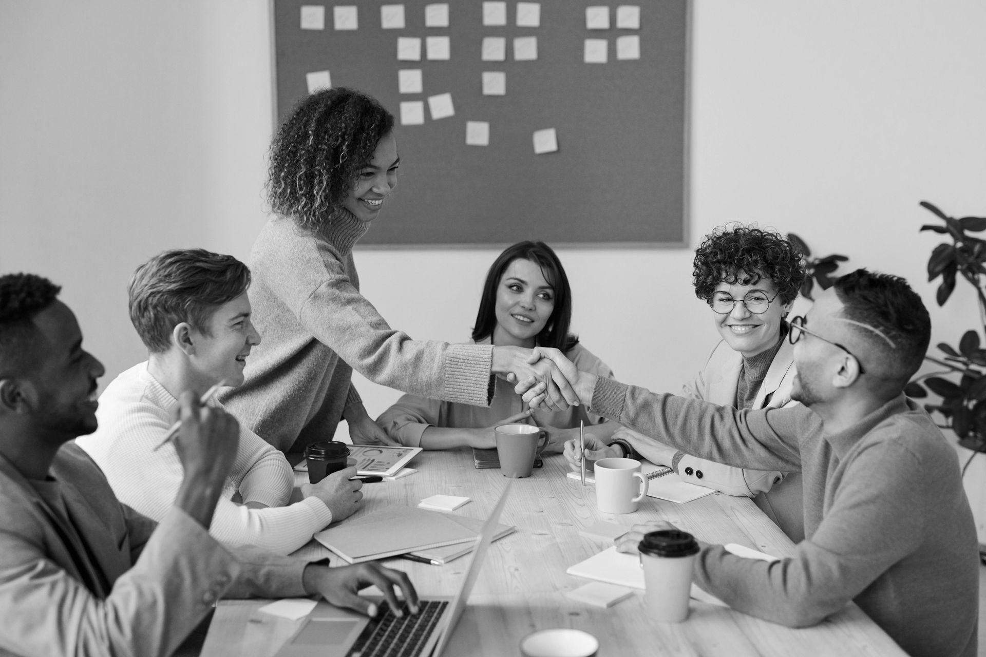 A group of people are working on a laptop computer in an office.
