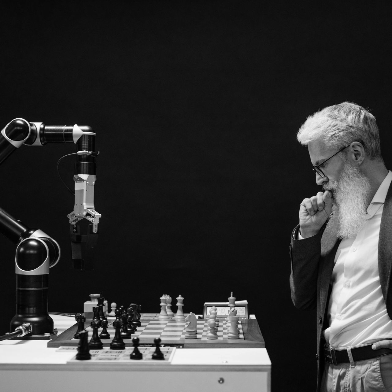 A group of people are sitting around a table looking at a laptop.