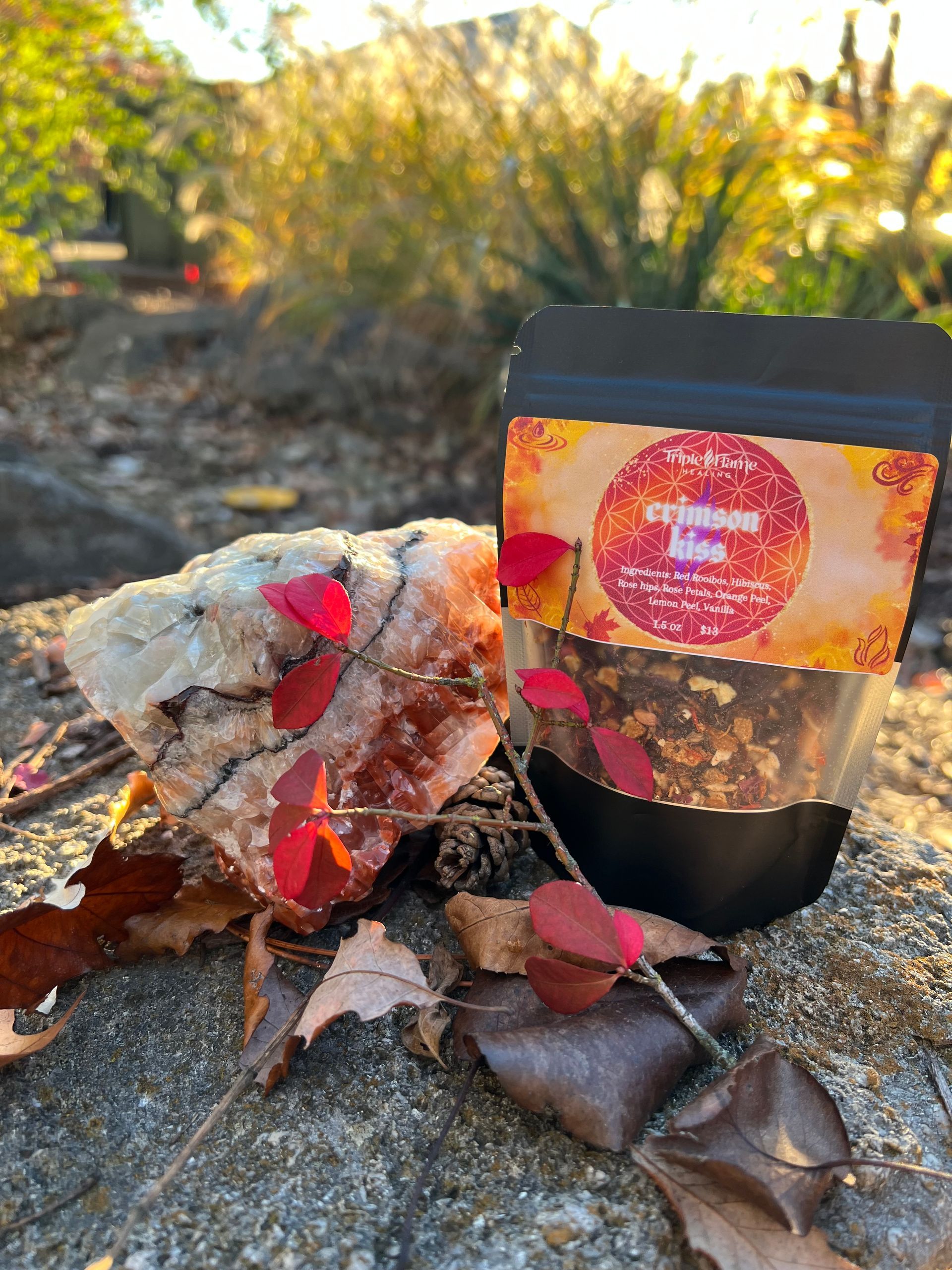 A bag of food is sitting on a rock next to a pile of leaves.