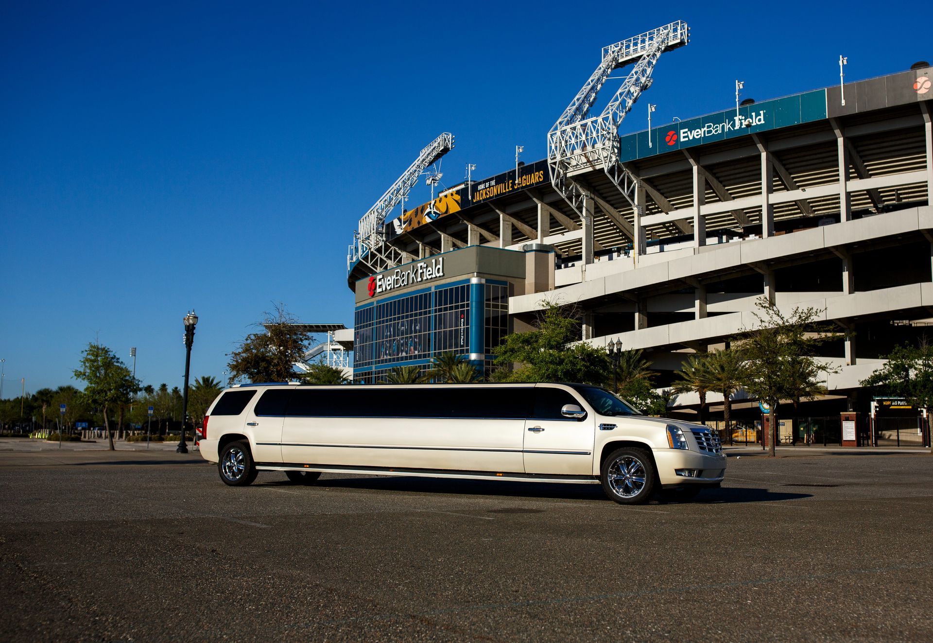 White stretch limousine parked outside a baseball stadium on a sunny day