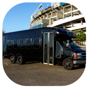 Black luxury coach bus parked outside a stadium on a sunny day