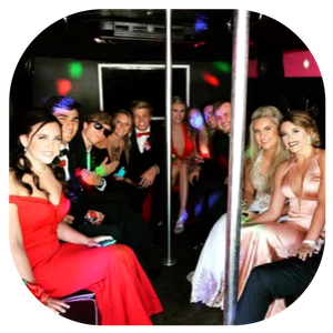 People dressed up in a limousine nightclub, seated around a pole with colorful party lights