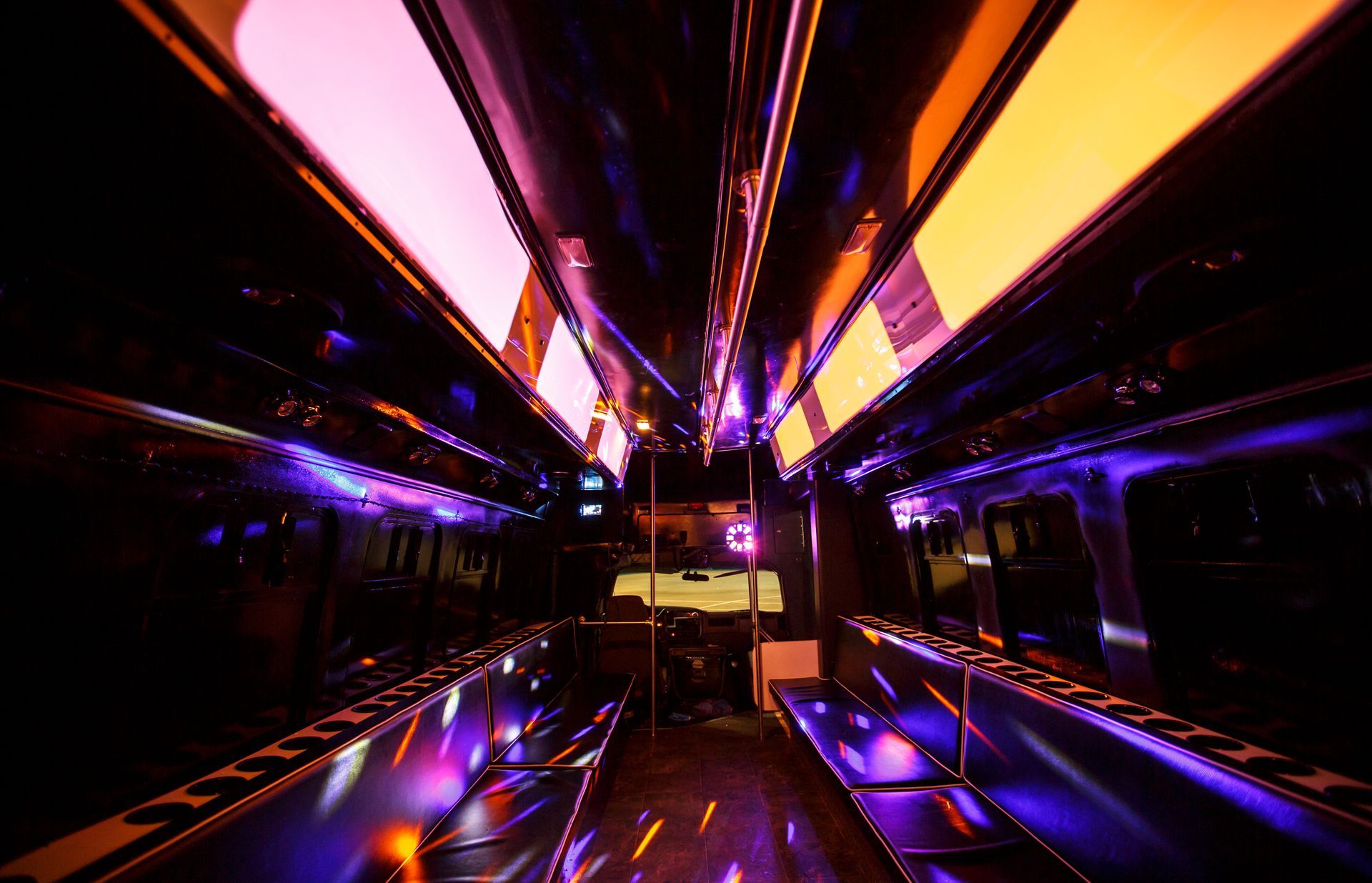 Neon-lit futuristic tunnel with purple and orange lights reflecting on a glossy floor
