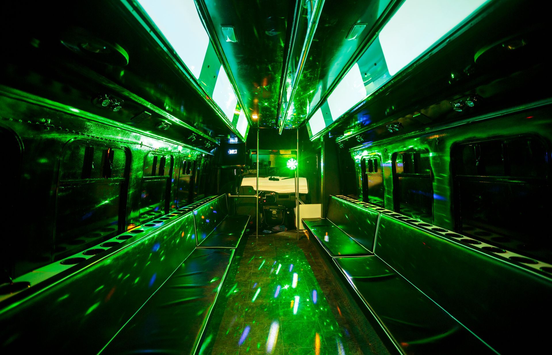 Green-lit empty subway car interior with shiny floors and rows of seats