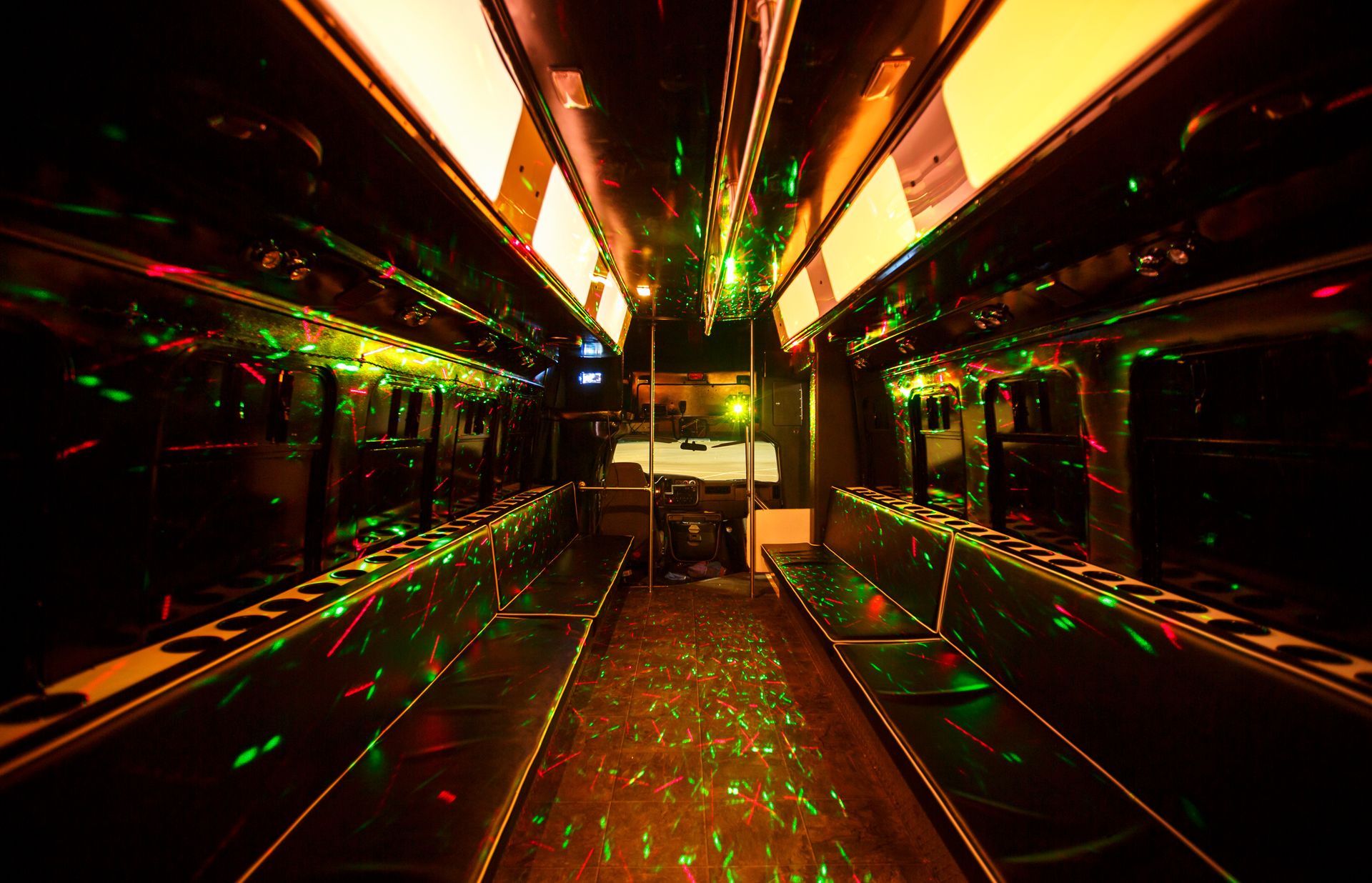 Empty subway train car with mirrored walls and neon green and orange reflections at night