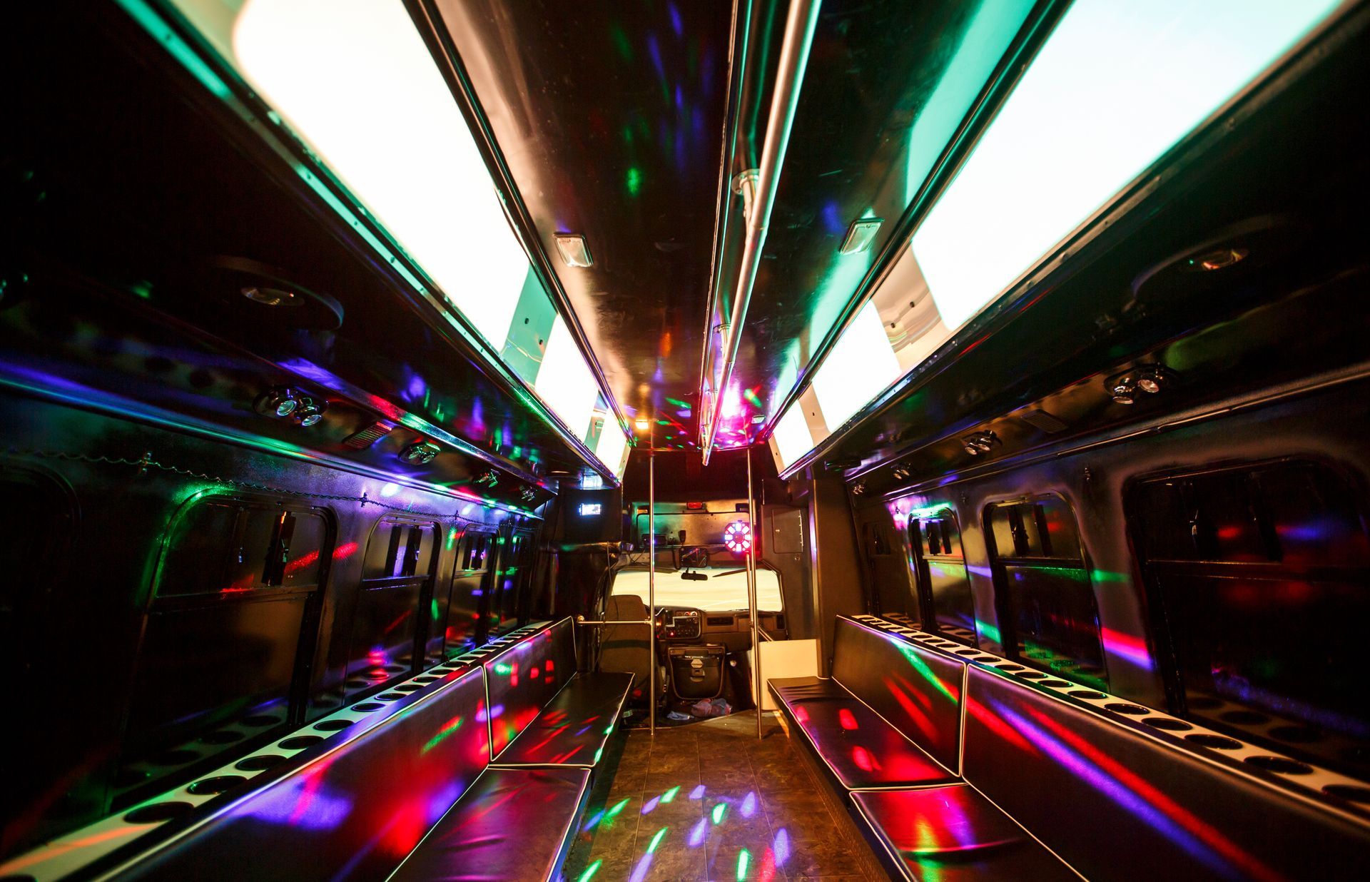 Neon-lit subway car interior with colorful reflections and empty seats
