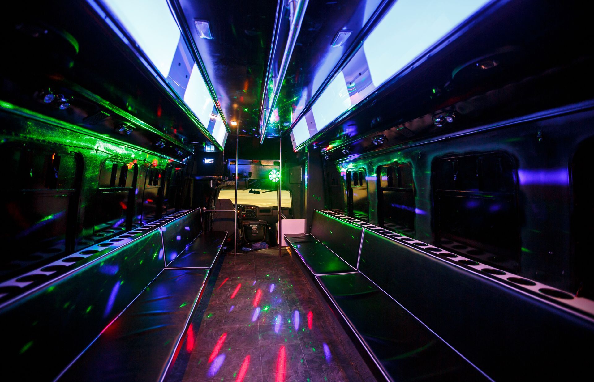 Empty party bus interior with neon lights and reflective seats
