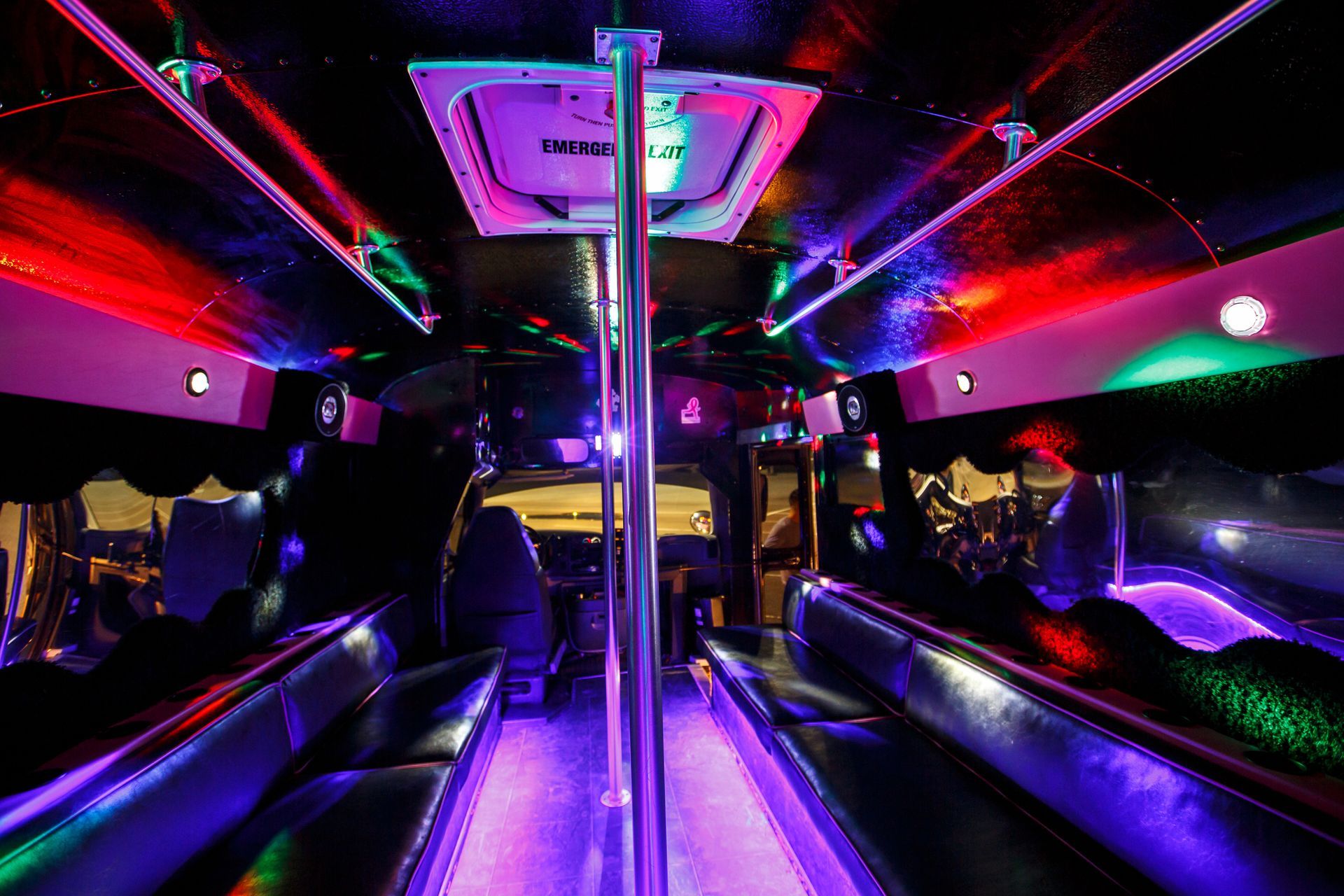 Neon-lit limousine interior with purple and red lights, leather seats, and a central pole