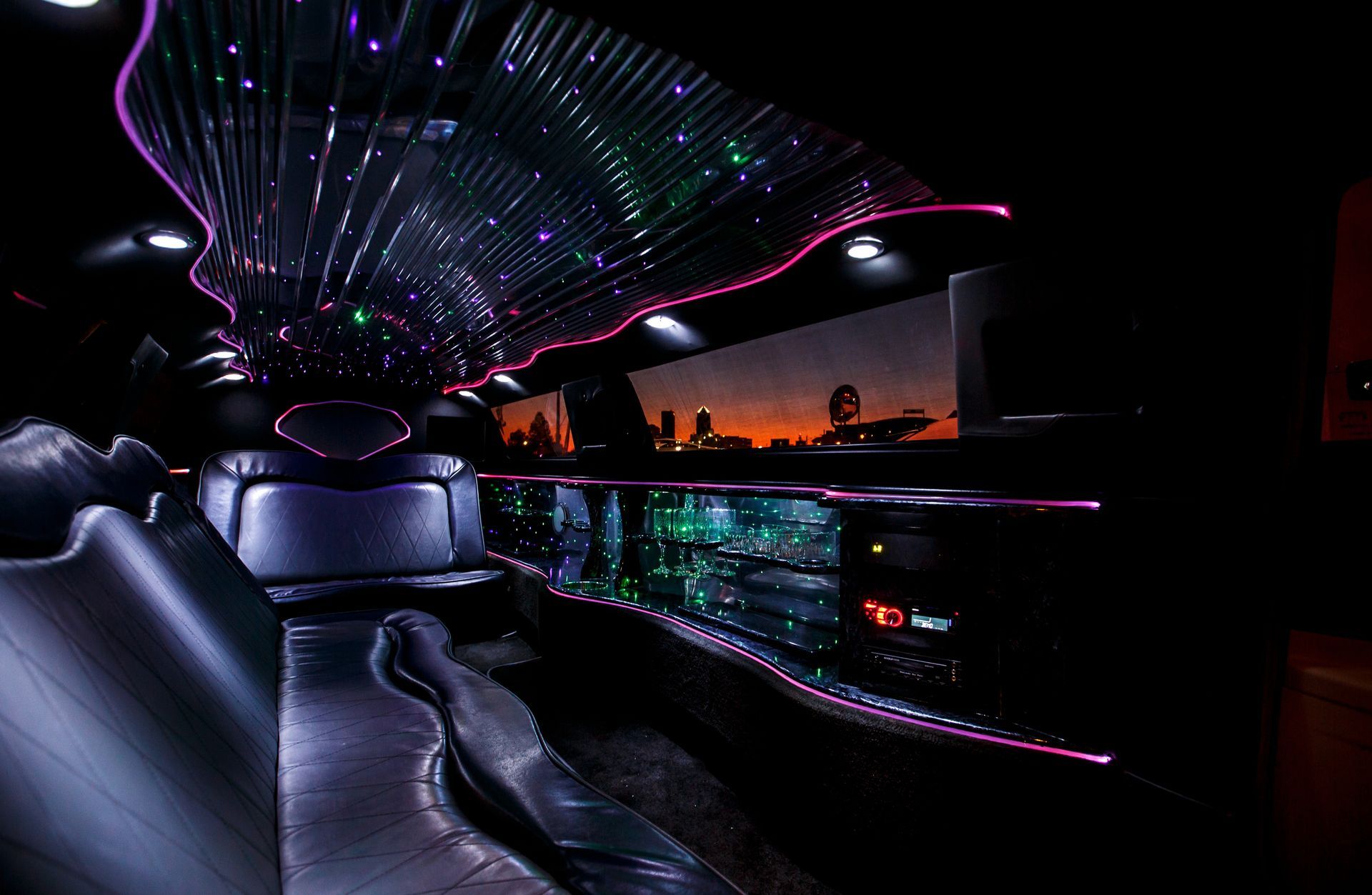 Neon-lit lounge with curved sofas, starry ceiling lights, and a glowing bar in a dark interior