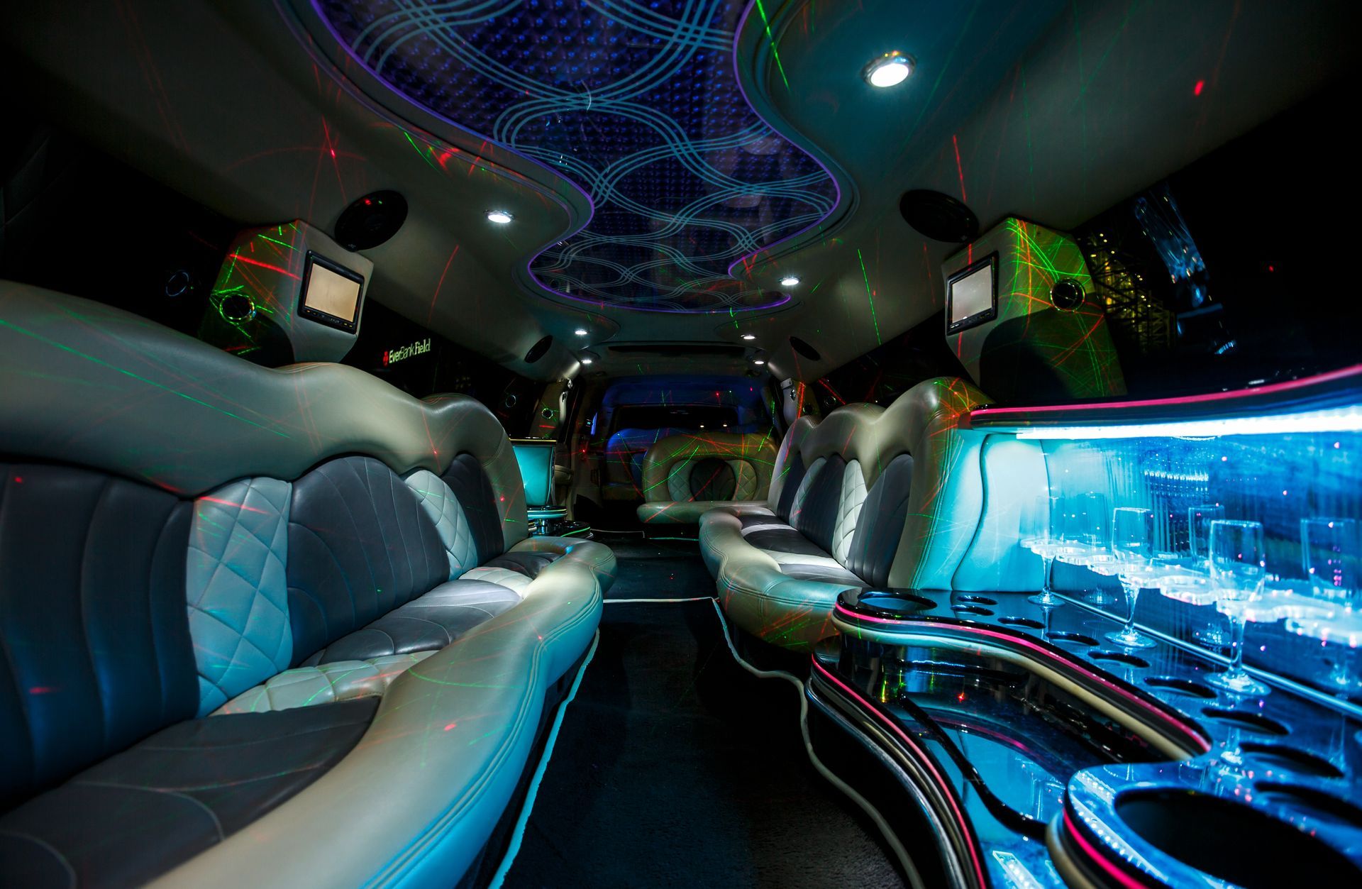 Luxurious limousine interior with blue neon lights, leather seats, and a mirrored ceiling
