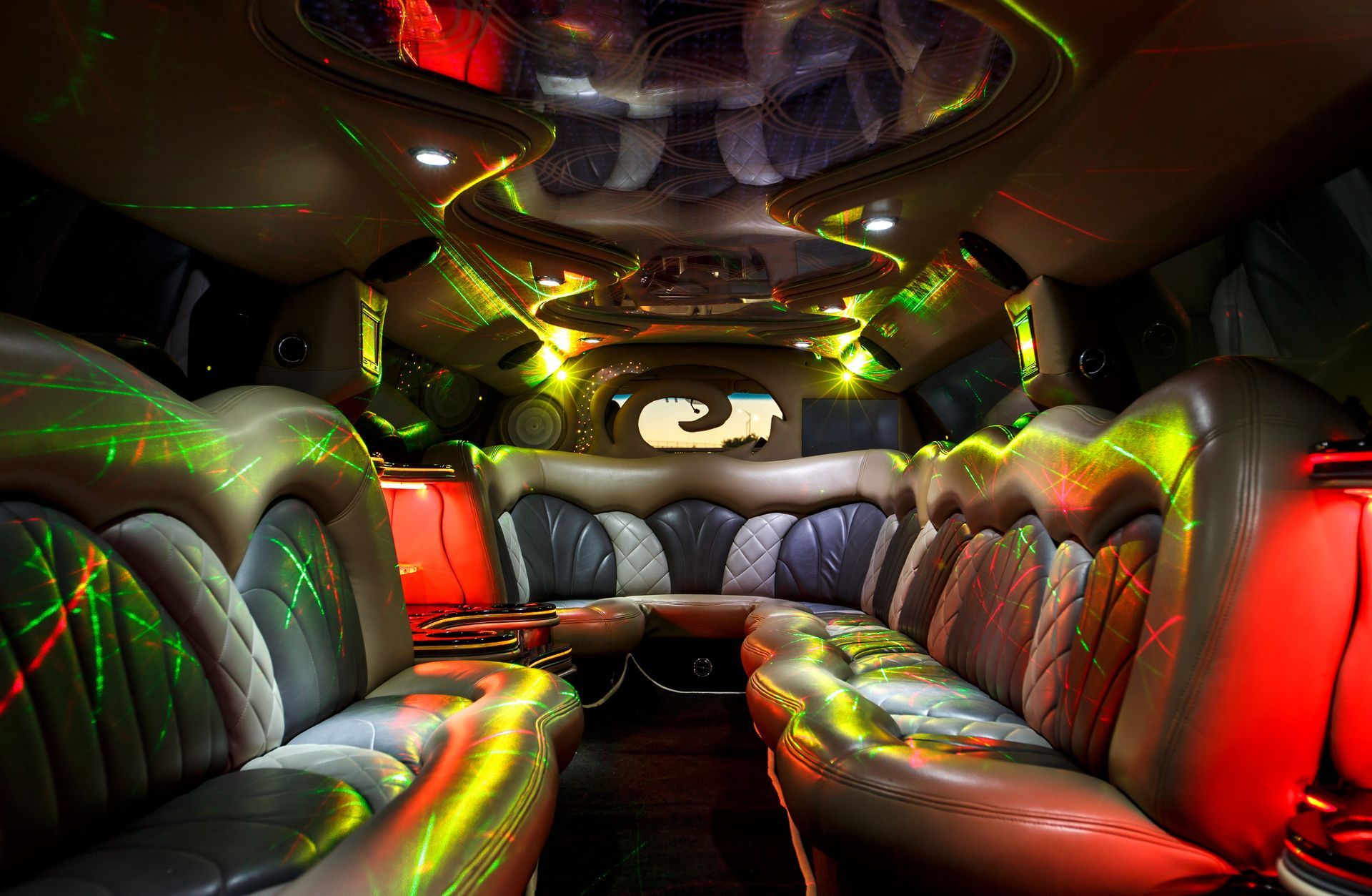 Luxurious limousine interior with black leather seats and colorful neon lighting