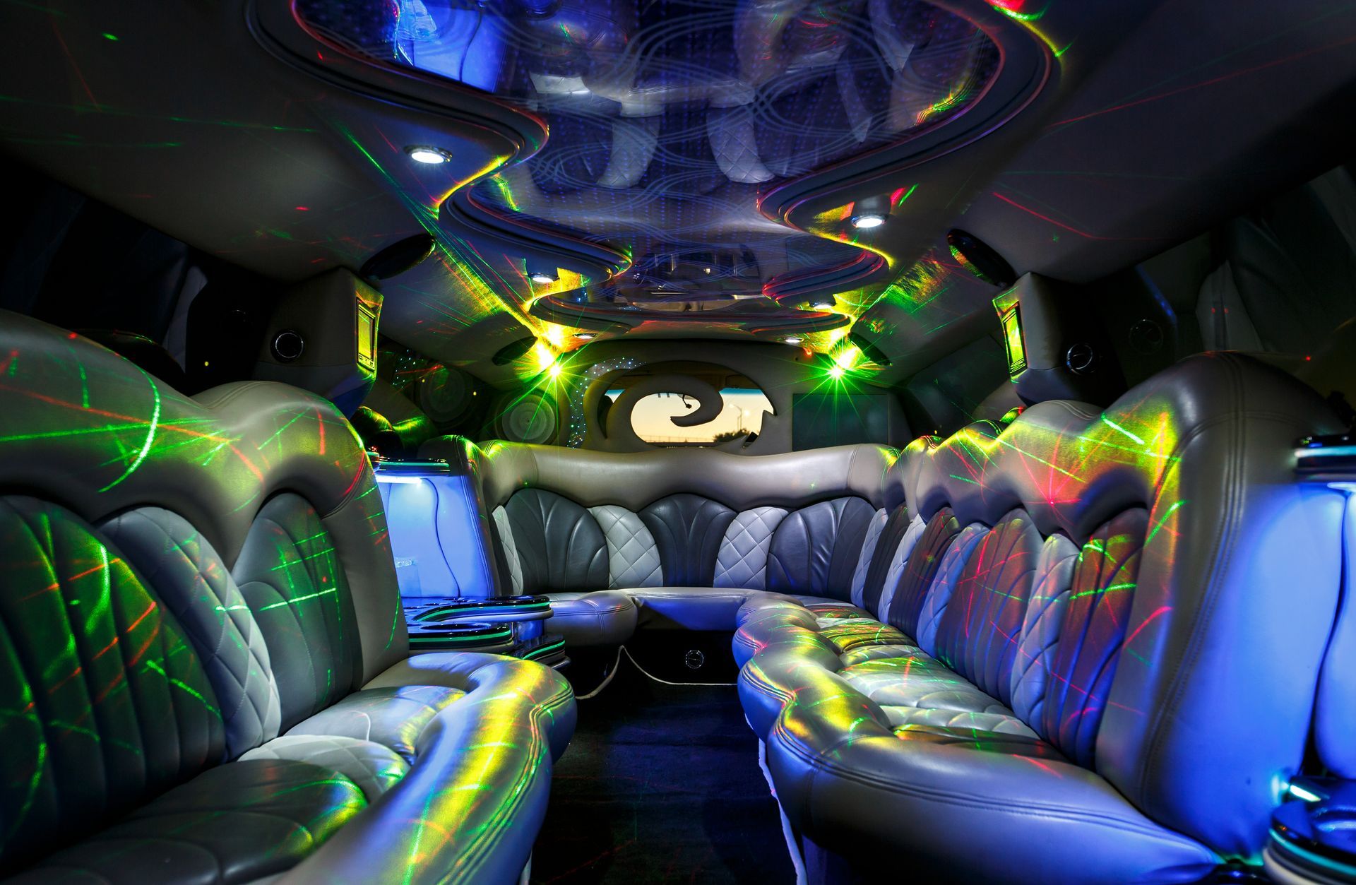 LED-lit limousine interior with black leather seats and colorful neon lighting