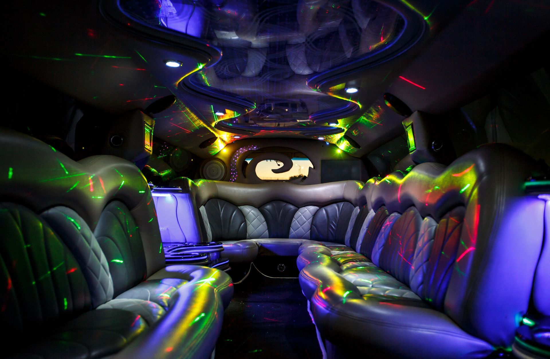 Luxurious black limousine interior with colorful LED lighting and leather seats
