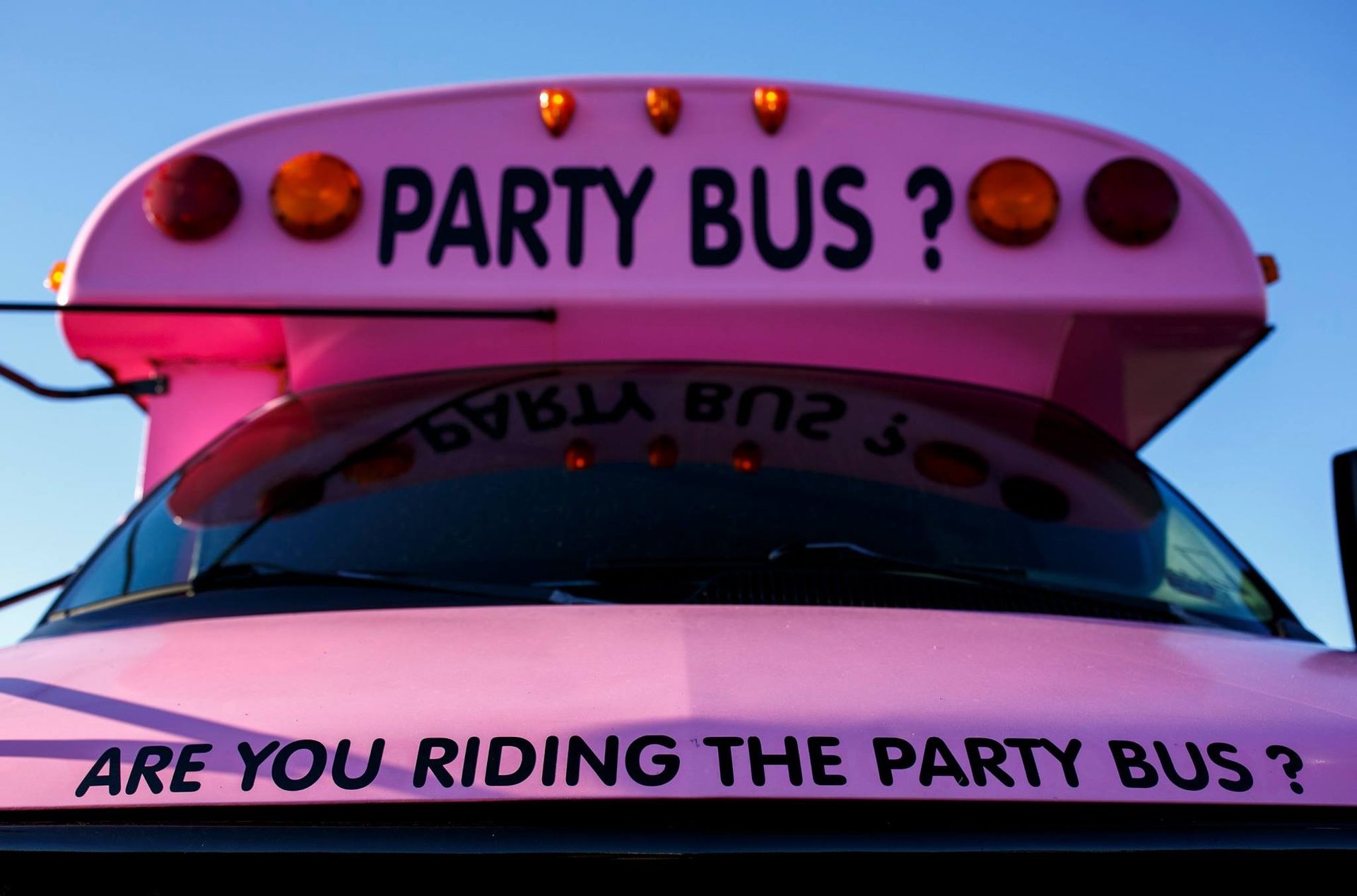 Pink party bus front with bold “PARTY BUS?” and “ARE YOU RIDING THE PARTY BUS?” text on the windshield