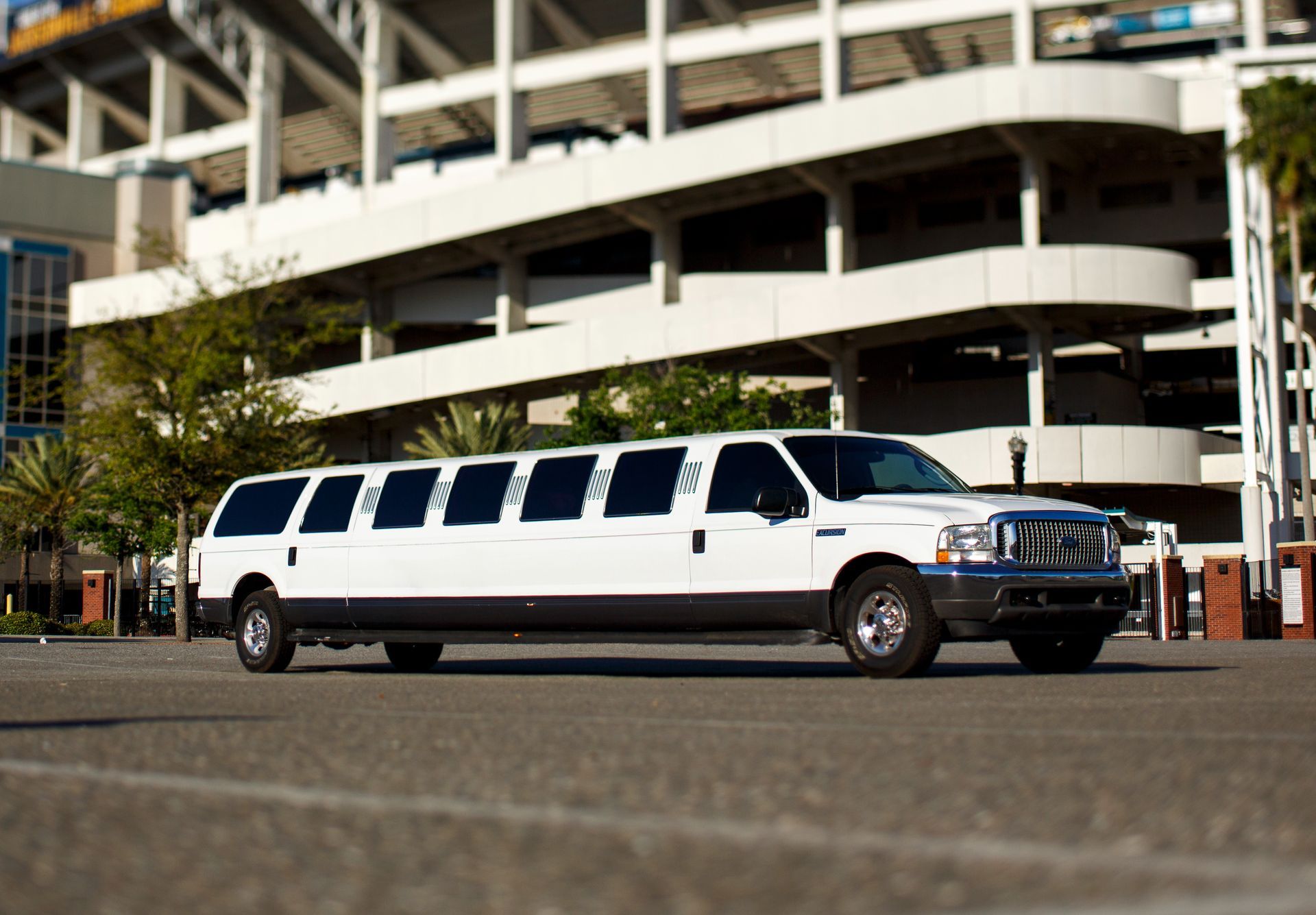 White stretch limousine parked outside a multi-level building