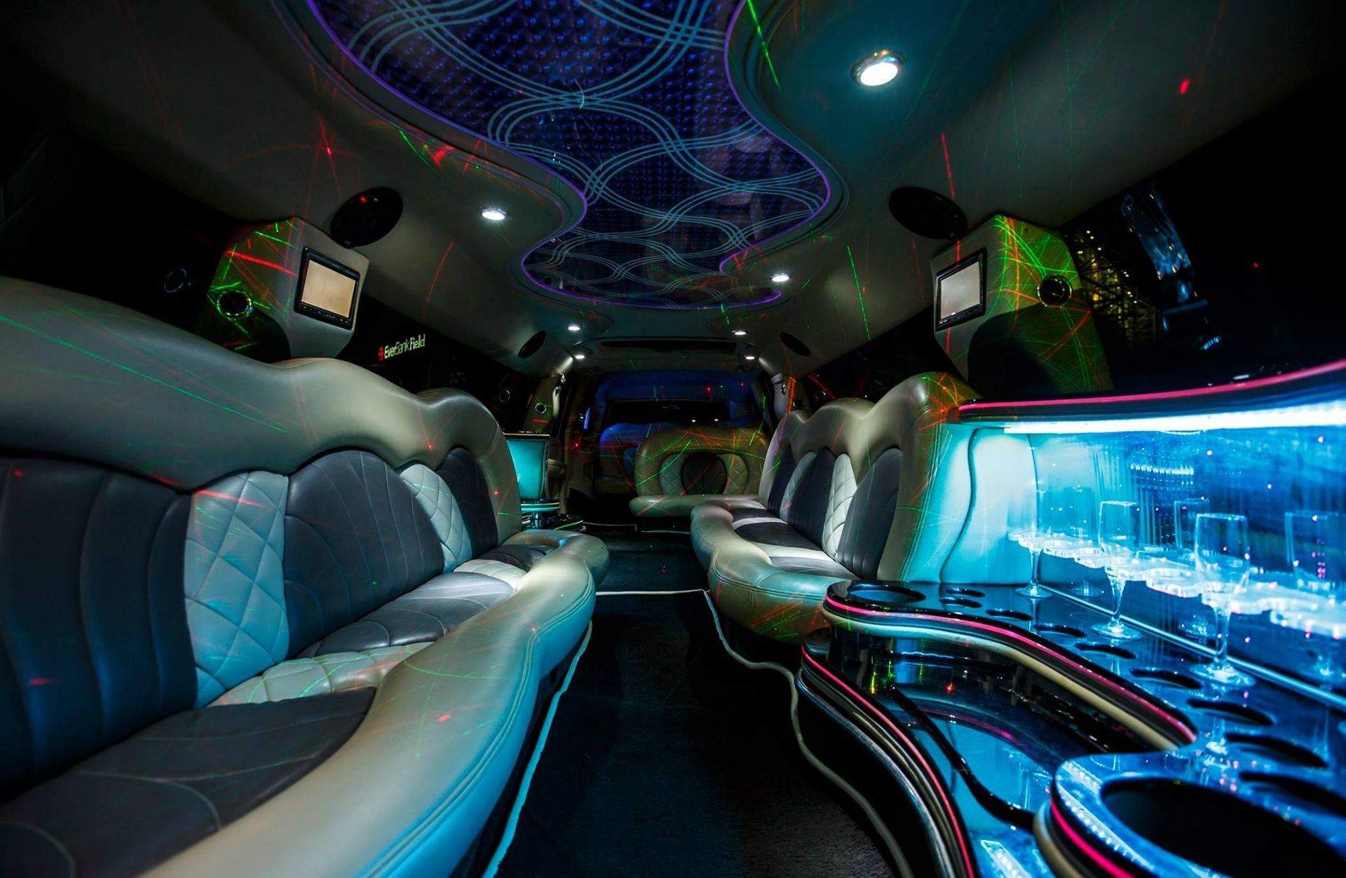 Luxurious limousine interior with blue neon lighting, leather seats, and illuminated ceiling patterns