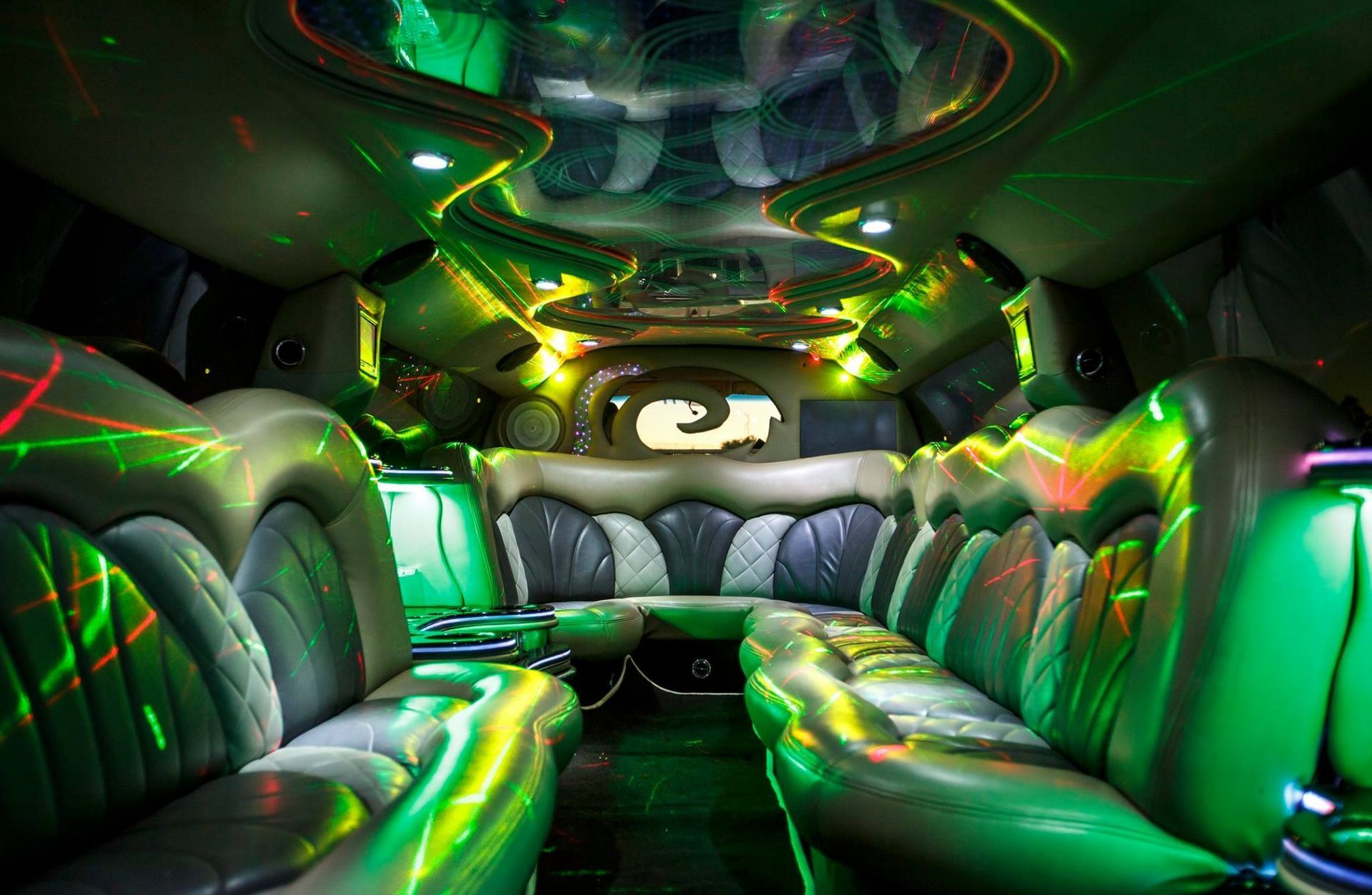 Neon-lit inflatable bus interior with green, silver, and black seating and a central aisle