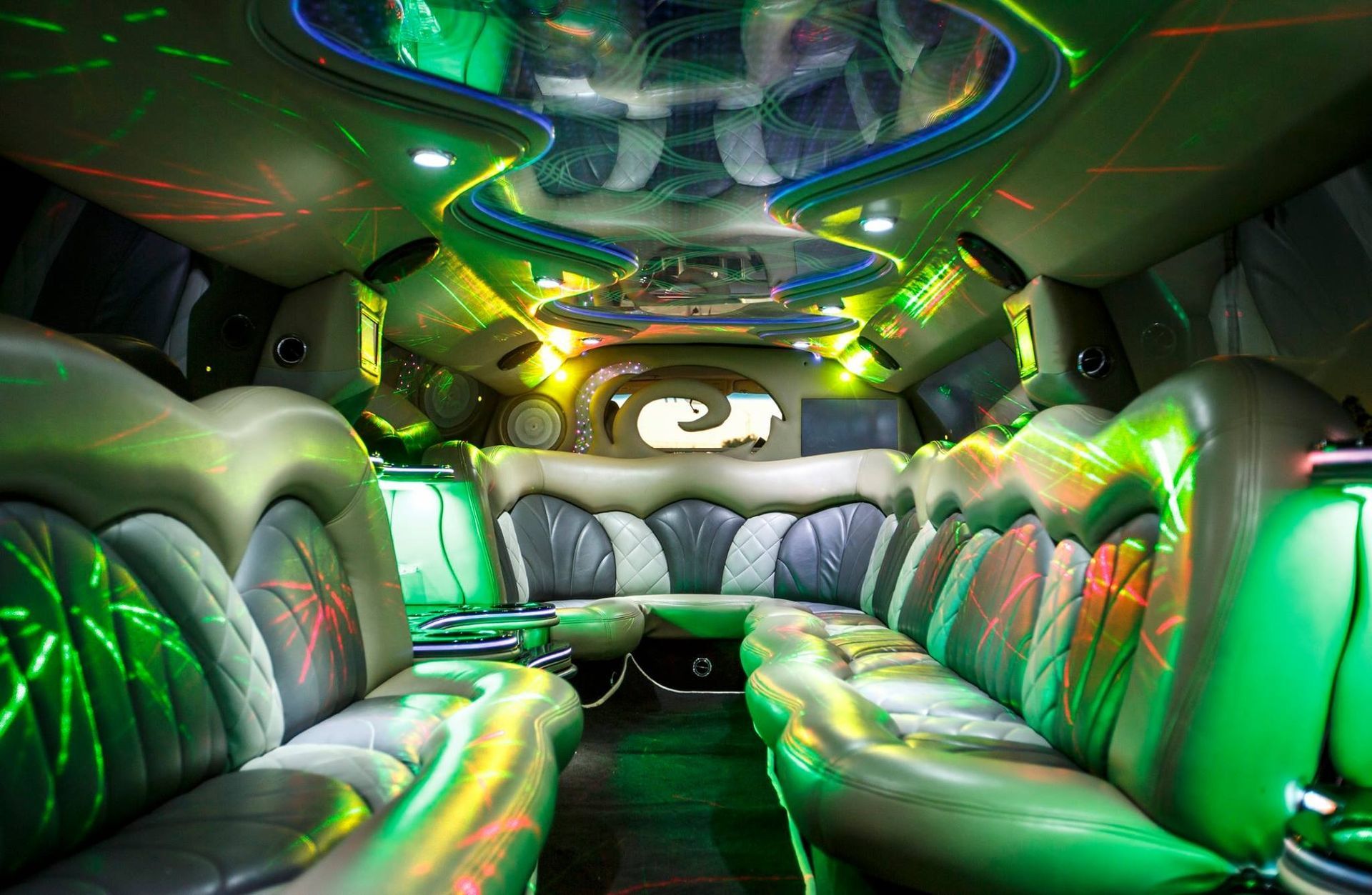 Futuristic car interior with silver seats and glowing green and yellow LED lighting