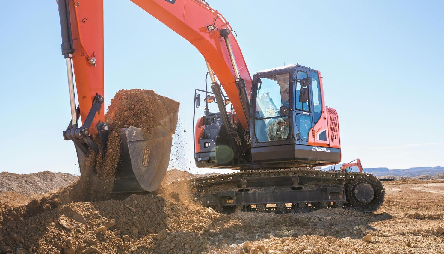 An excavator is digging a hole in the dirt on a construction site.