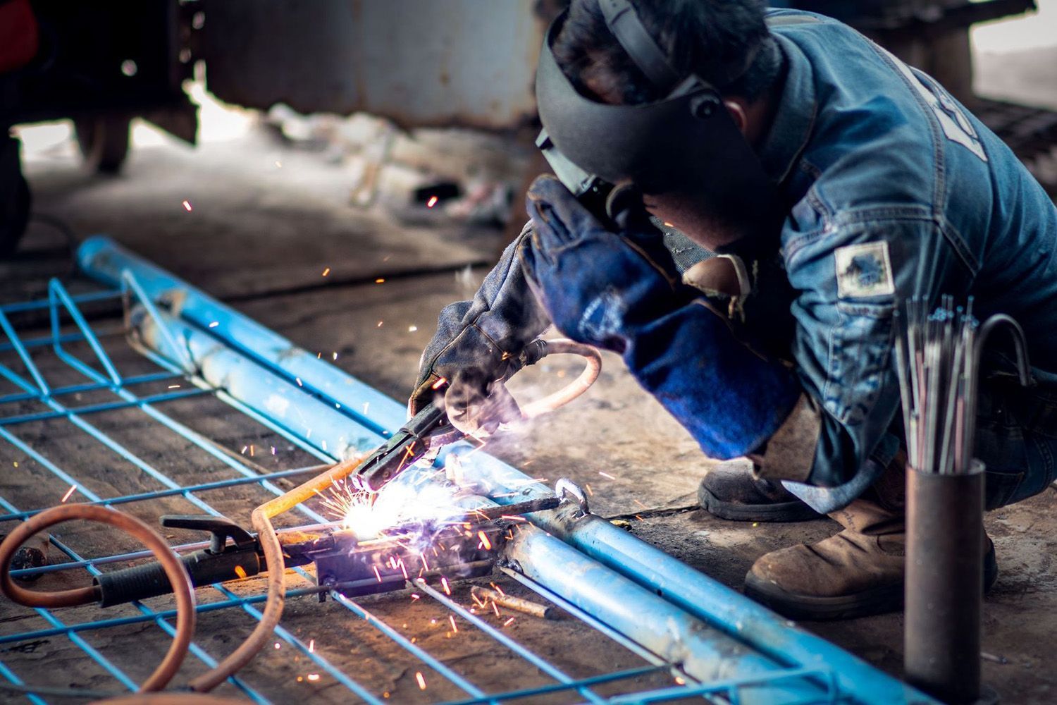Welder In Blue Protective Gear, Welding Blue Steel Gate
