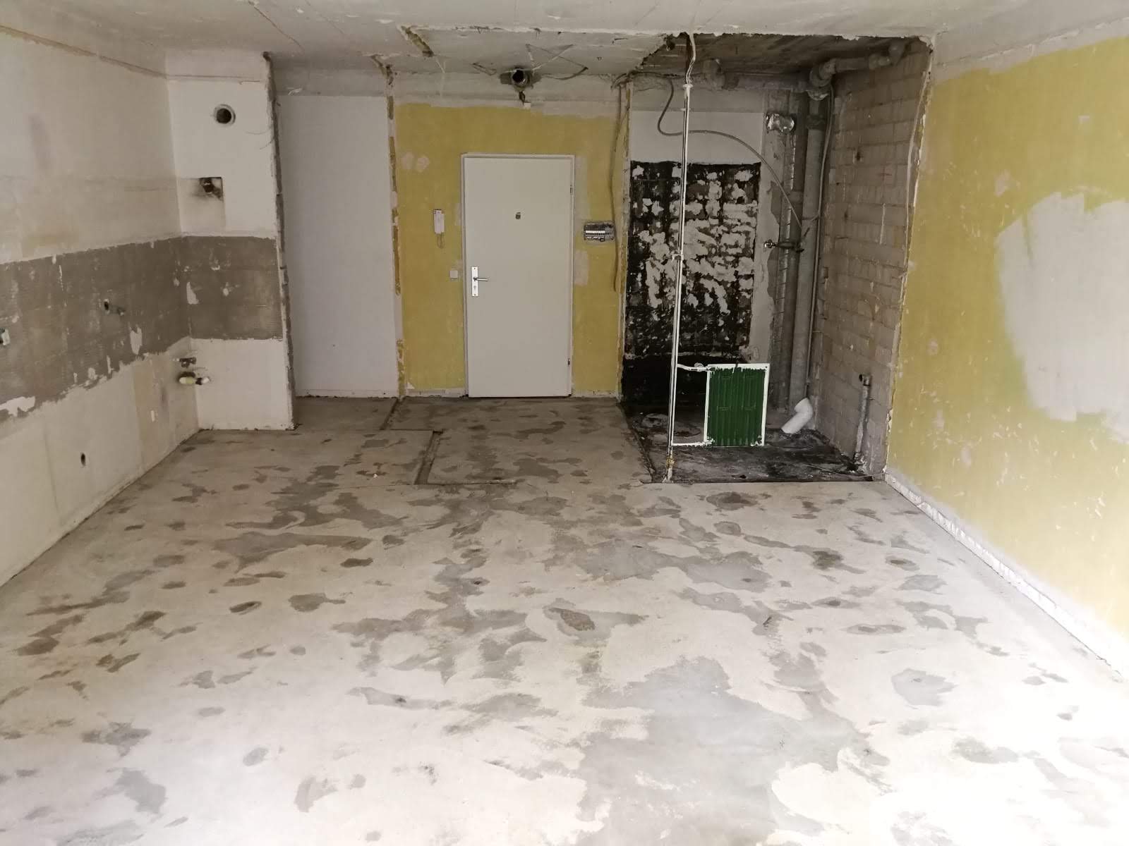 Leerer Raum mit gelben und Betonwänden, der gerade renoviert wird.