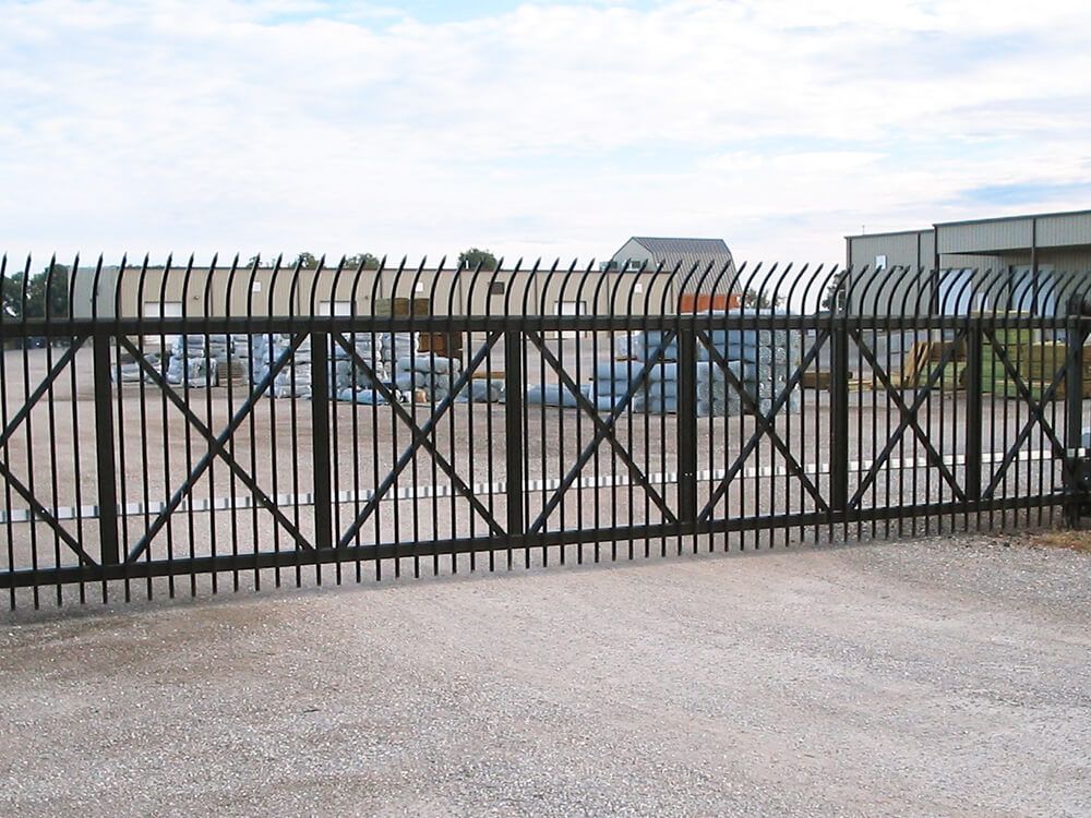 A sliding gate with a fence surrounding it | Commercial fencing cantiliever security